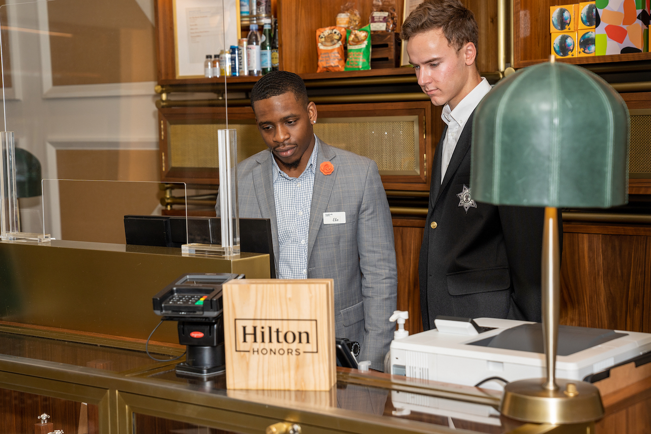 "Hospitality staff providing friendly service to guests in a hotel lobby